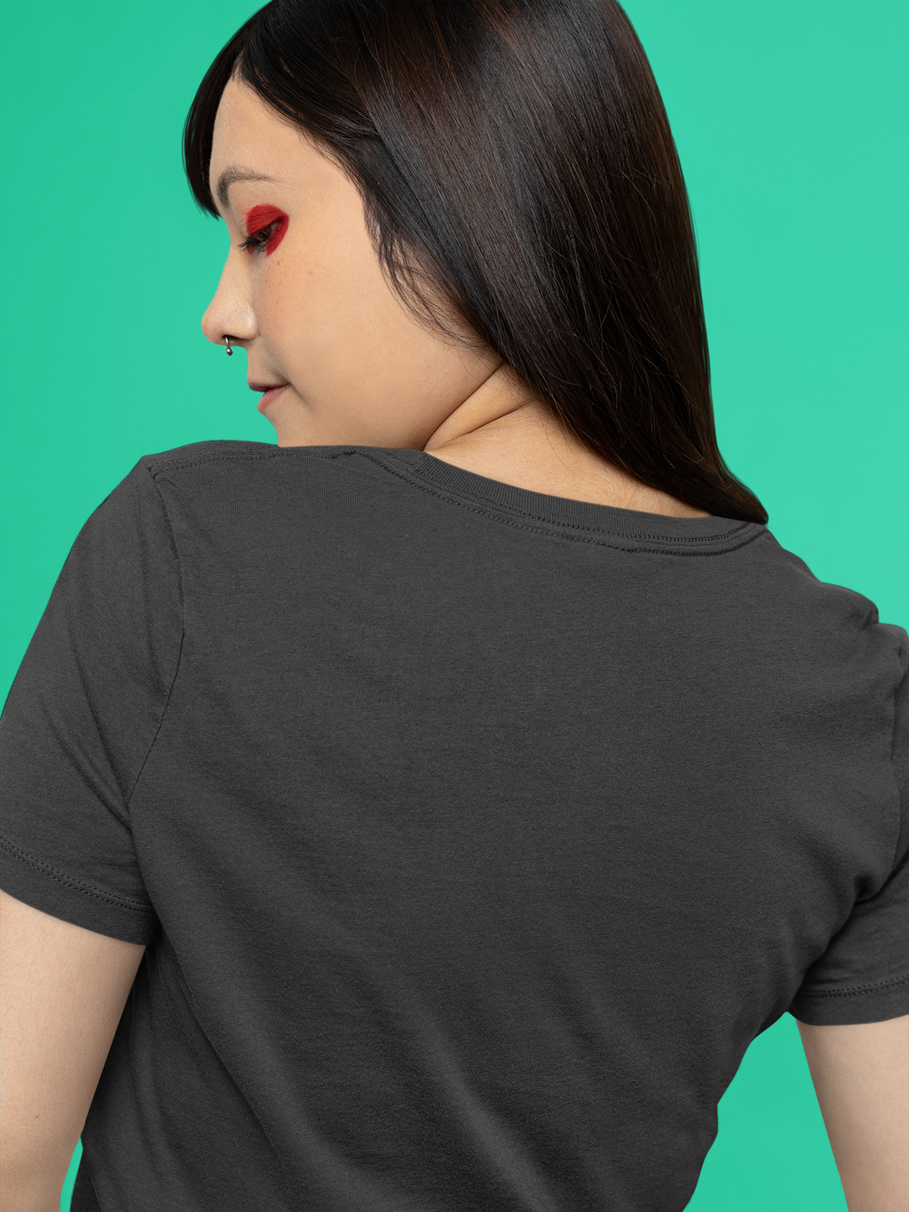 Orbit Keeper Garment-Dyed Tee in Black, worn by a woman seen from behind against green, showing the large print on the back. Digital product mockup.