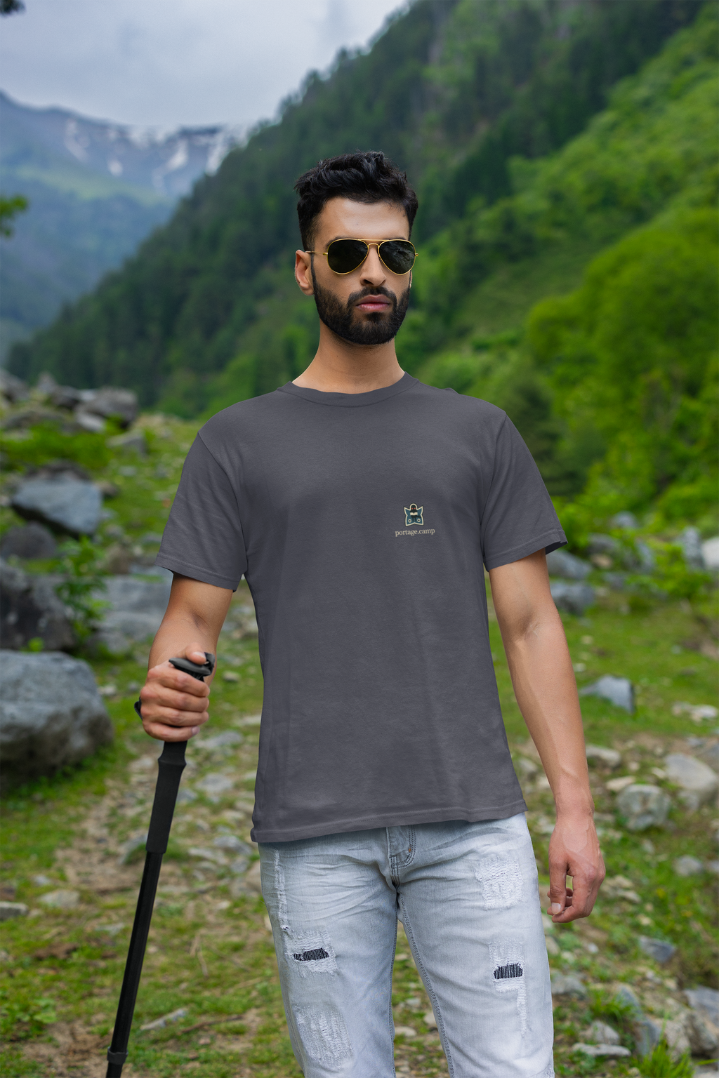 Night Library Garment-Dyed Tee in Navy, worn by a man on a mountain trail, with the Night Library logo and portage.camp on the chest. Digital product mockup.