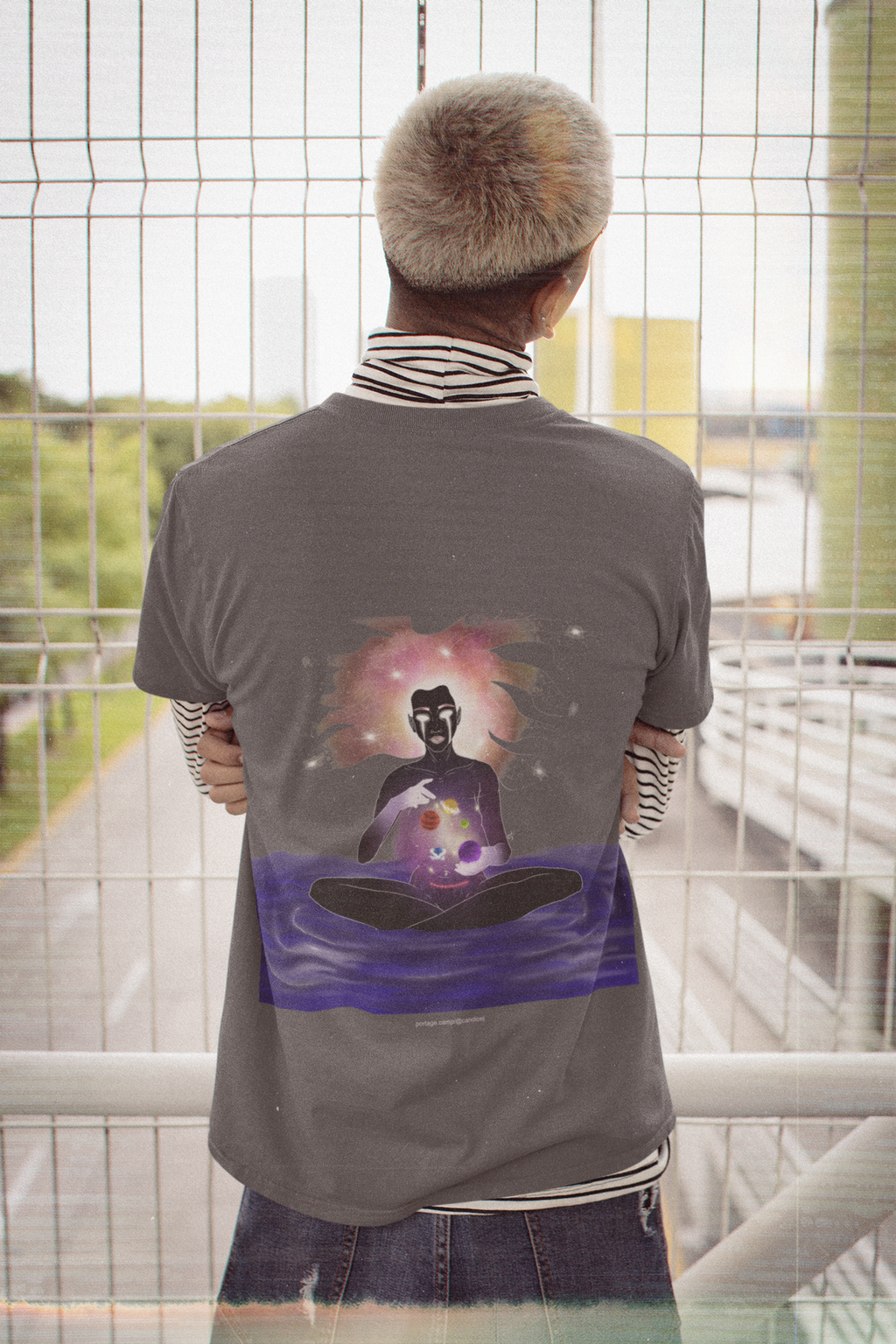 Orbit Keeper Garment-Dyed Tee in Graphite, worn by a man seen from behind in a nineties grunge outfit, showing the large print on the back. Digital product mockup.
