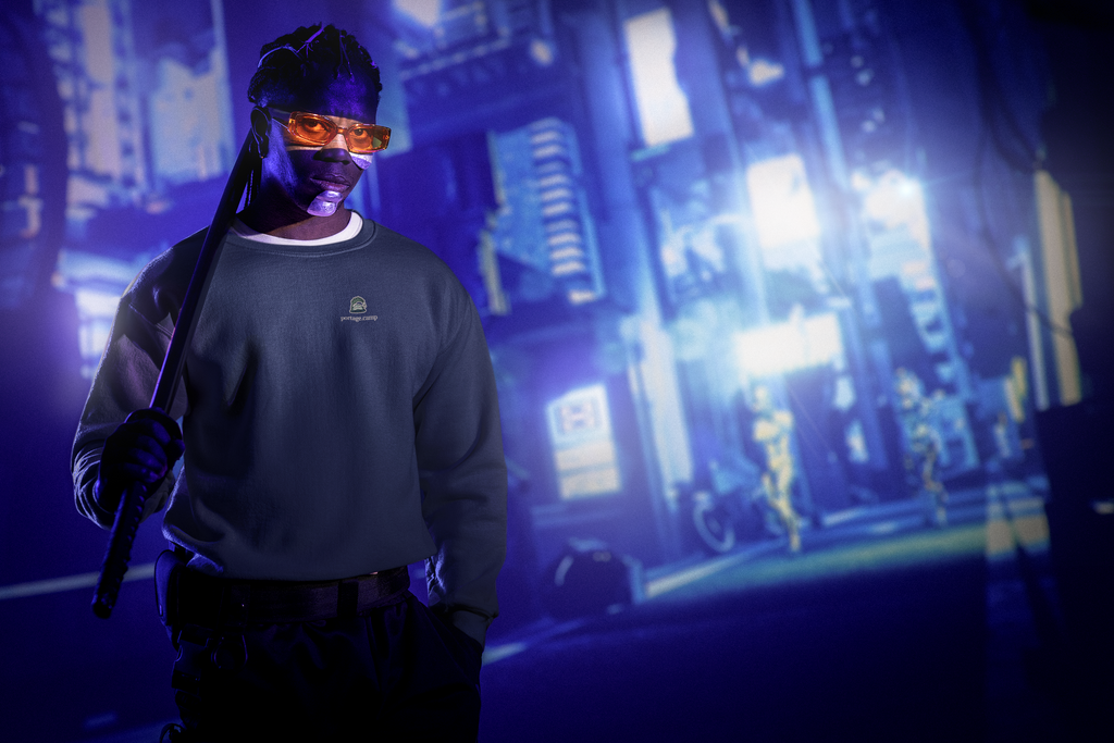 Rain Check Garment-Dyed Crewneck in True Navy, worn by a man under neon city lights, with the Rain Check logo and portage.camp on the chest. Digital product mockup.