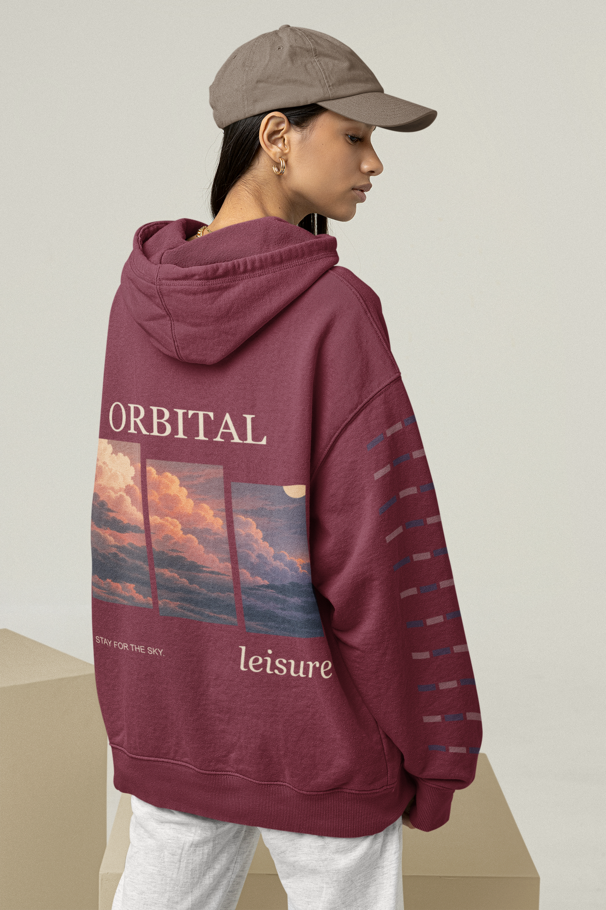 Stay for the Sky Midweight Hoodie in Maroon, worn by a woman seen from behind in a studio, showing the large print on the back. Digital product mockup.
