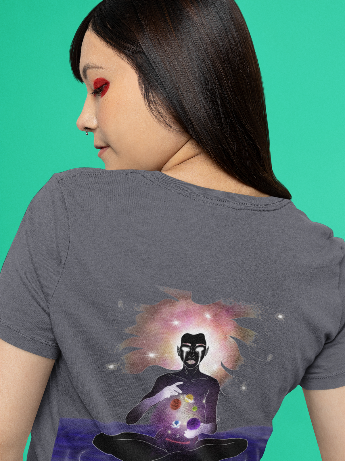 Orbit Keeper Garment-Dyed Tee in Navy, worn by a woman seen from behind against green, showing the large print on the back. Digital product mockup.