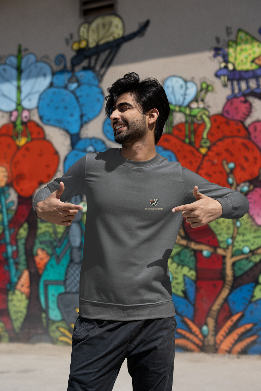Seen Briefly Garment-Dyed Crewneck in Pepper, worn by a man on a city street, with the Seen Briefly logo and portage.camp on the chest. Digital product mockup.