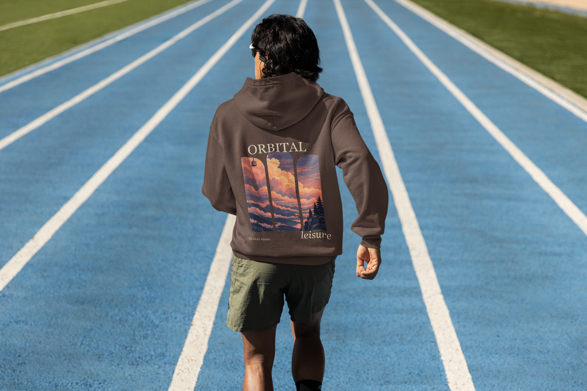 Edge of Evening Heavyweight Hoodie in Brown, worn by a man seen from behind on a running track, showing the large print on the back. Digital product mockup.
