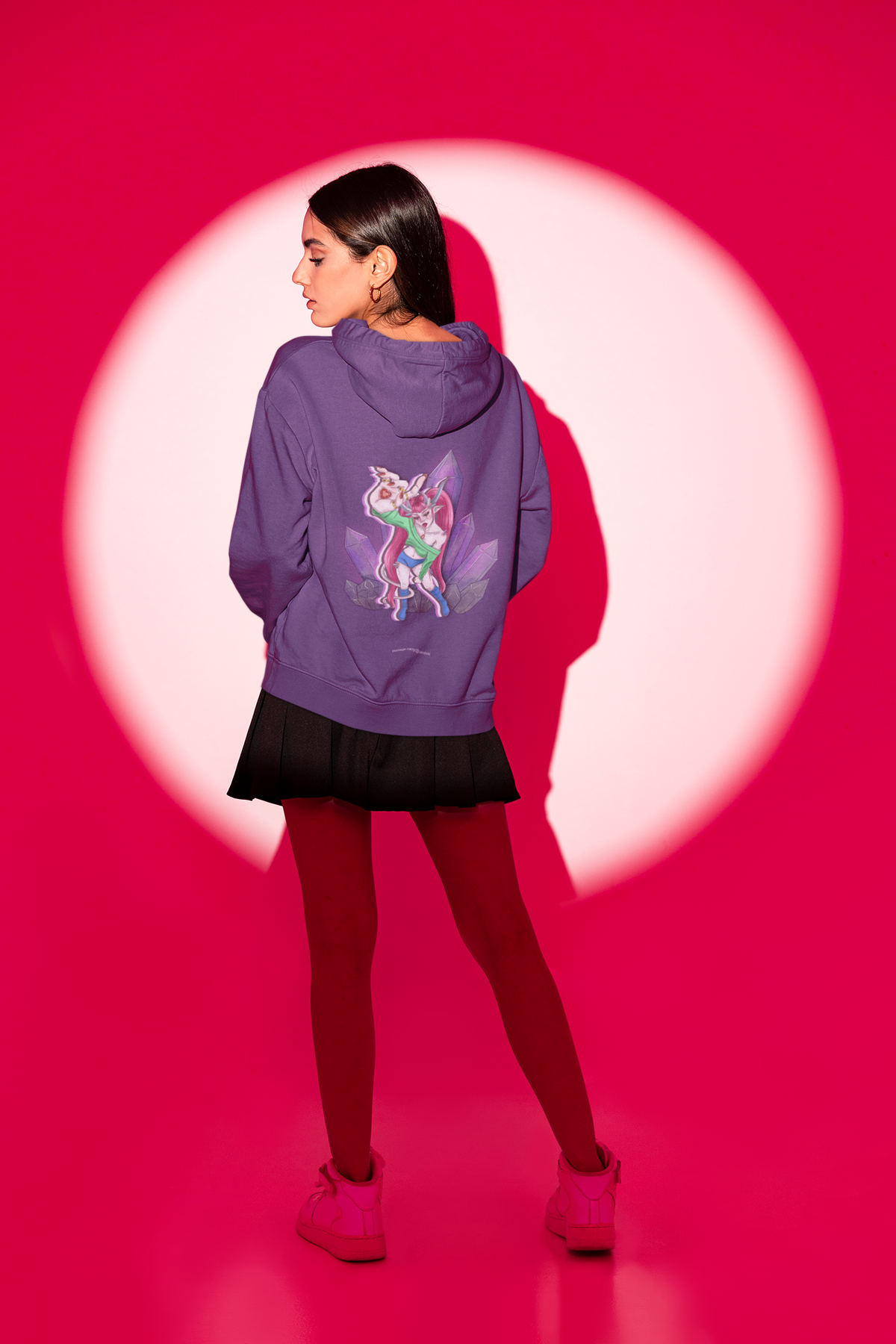 Amethyst After Hours Midweight Hoodie in Purple, worn by a woman seen from behind in a studio spotlight, showing the large print on the back. Digital product mockup.