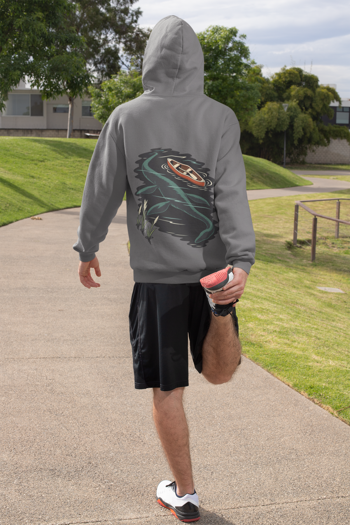 Seen Briefly Midweight Hoodie in Charcoal, worn by a man seen from behind on a sunny path, ready for a run, showing the large print on the back. Digital product mockup.