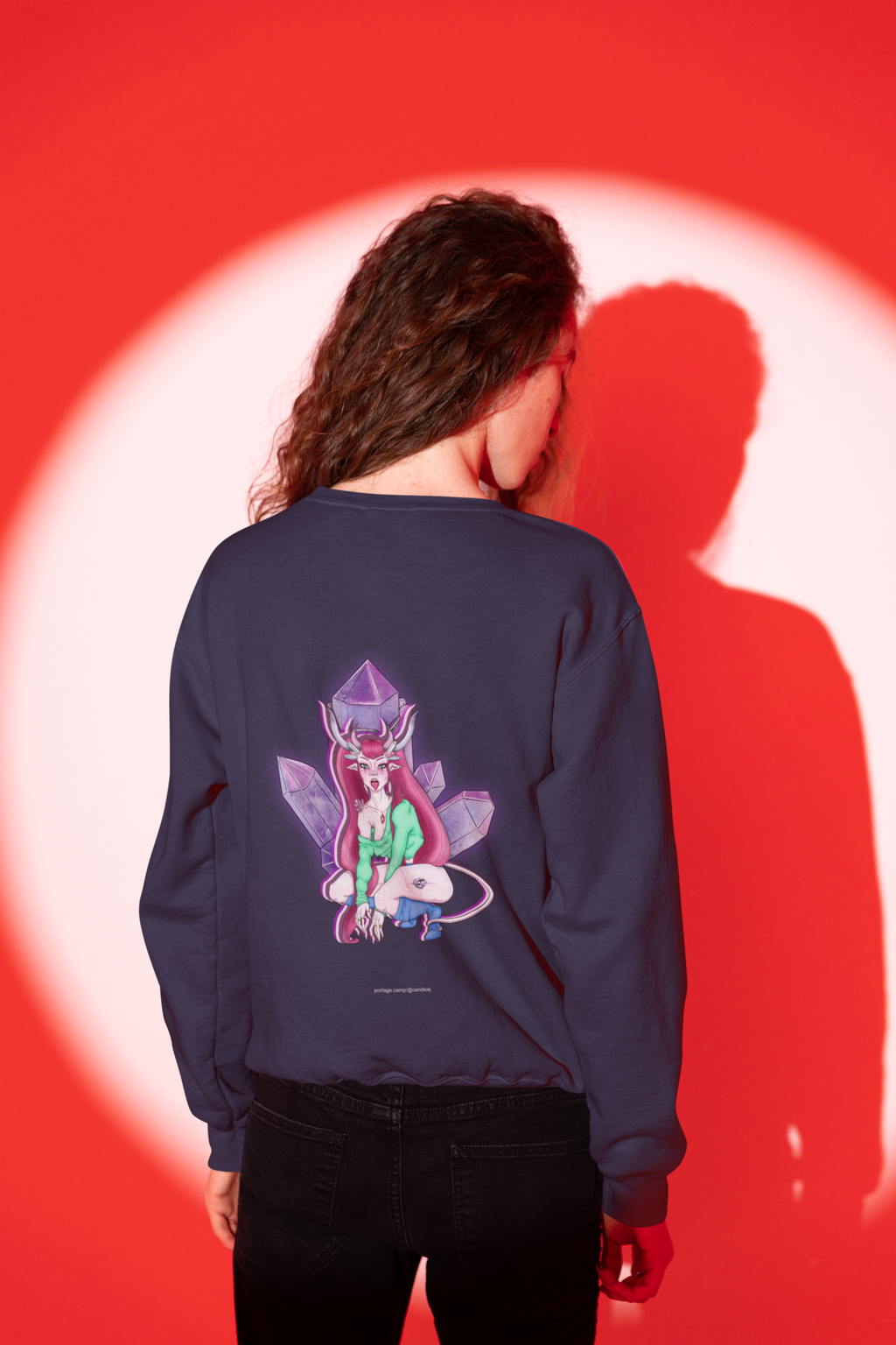 Heart Thief Garment-Dyed Crewneck in True Navy, worn by a man seen from behind in a studio, his shadow on the wall behind him, showing the large print on the back. Digital product mockup.