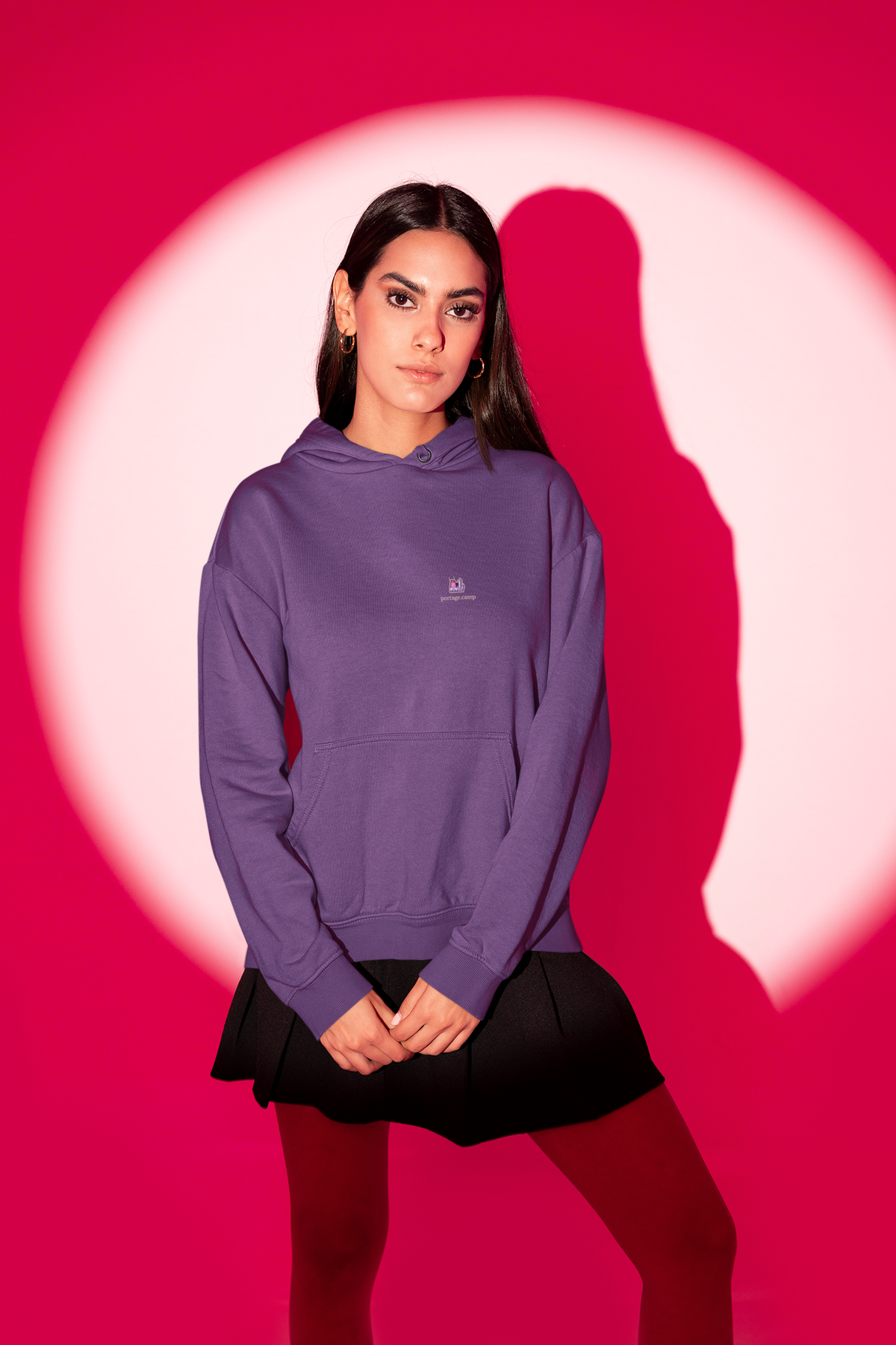 Amethyst After Hours Midweight Hoodie in Purple, worn by a woman in a red-lit studio, with the Amethyst After Hours logo and portage.camp on the chest. Digital product mockup.