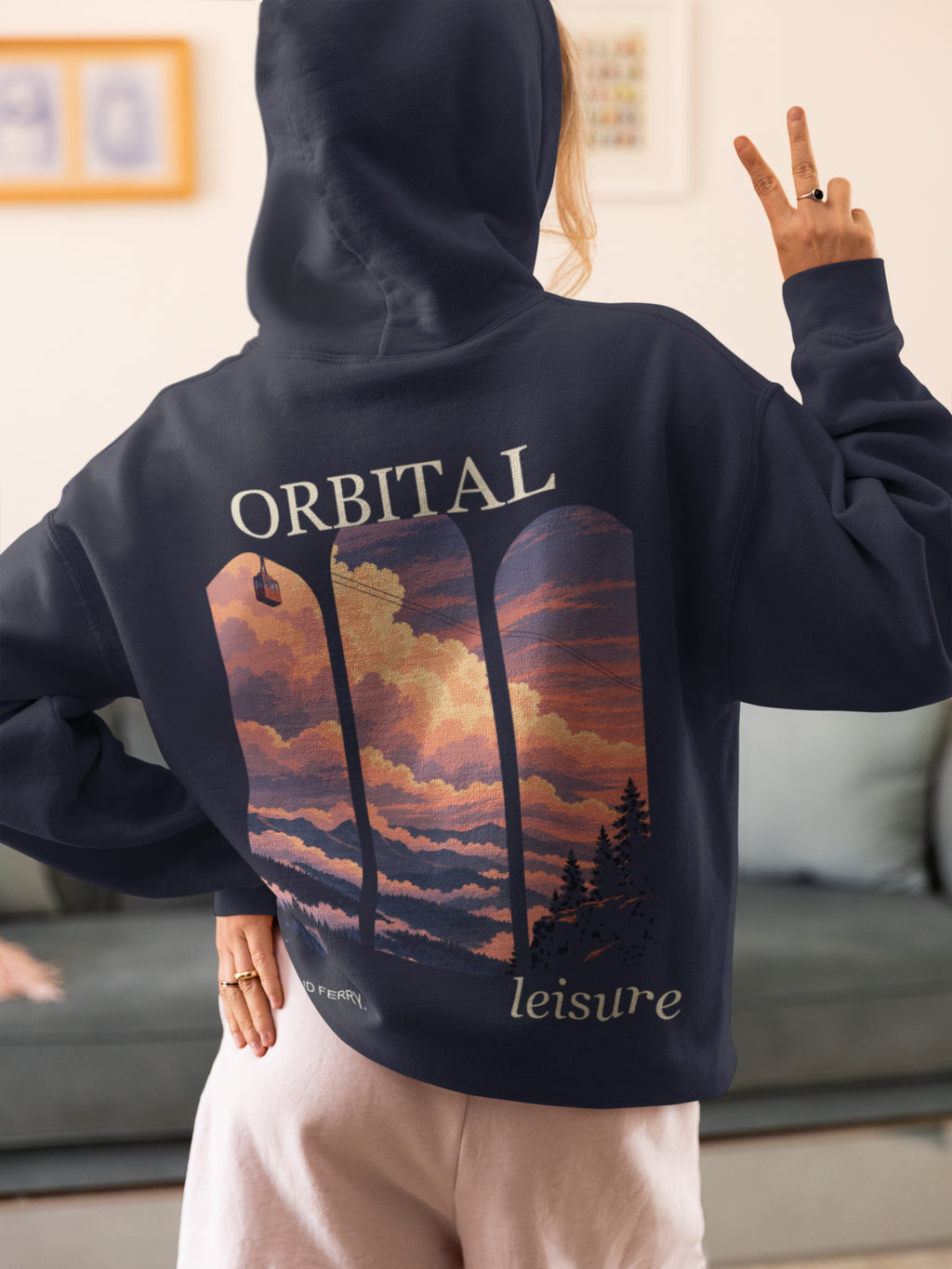 Cloud Ferry Zip Hoodie in Navy, worn by a woman seen from behind at home, making a peace sign, showing the large print on the back. Digital product mockup.