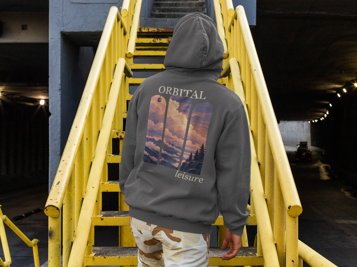 Cloud Ferry Zip Hoodie in Dark Heather, worn by a man seen from behind climbing a yellow metal staircase, showing the large print on the back. Digital product mockup.