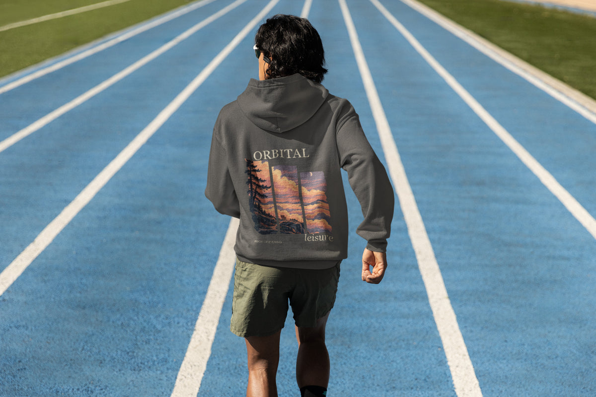 Edge of Evening Zip Hoodie in Dark Heather, worn by a man seen from behind on a running track, showing the large print on the back. Digital product mockup.
