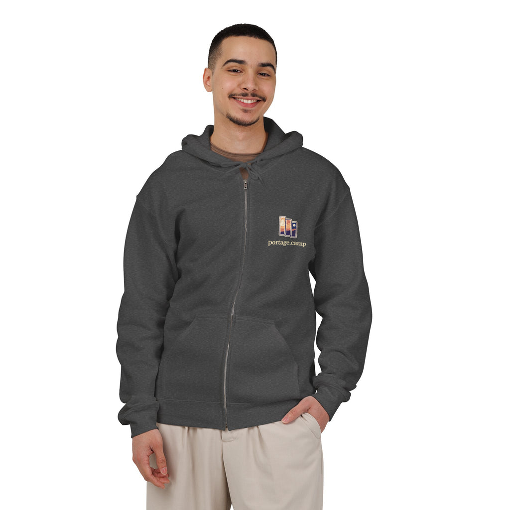 Stay for the Sky Zip Hoodie in Dark Heather, worn by a man in a plain white studio, with the Stay for the Sky logo and portage.camp on the left chest. Digital product mockup.
