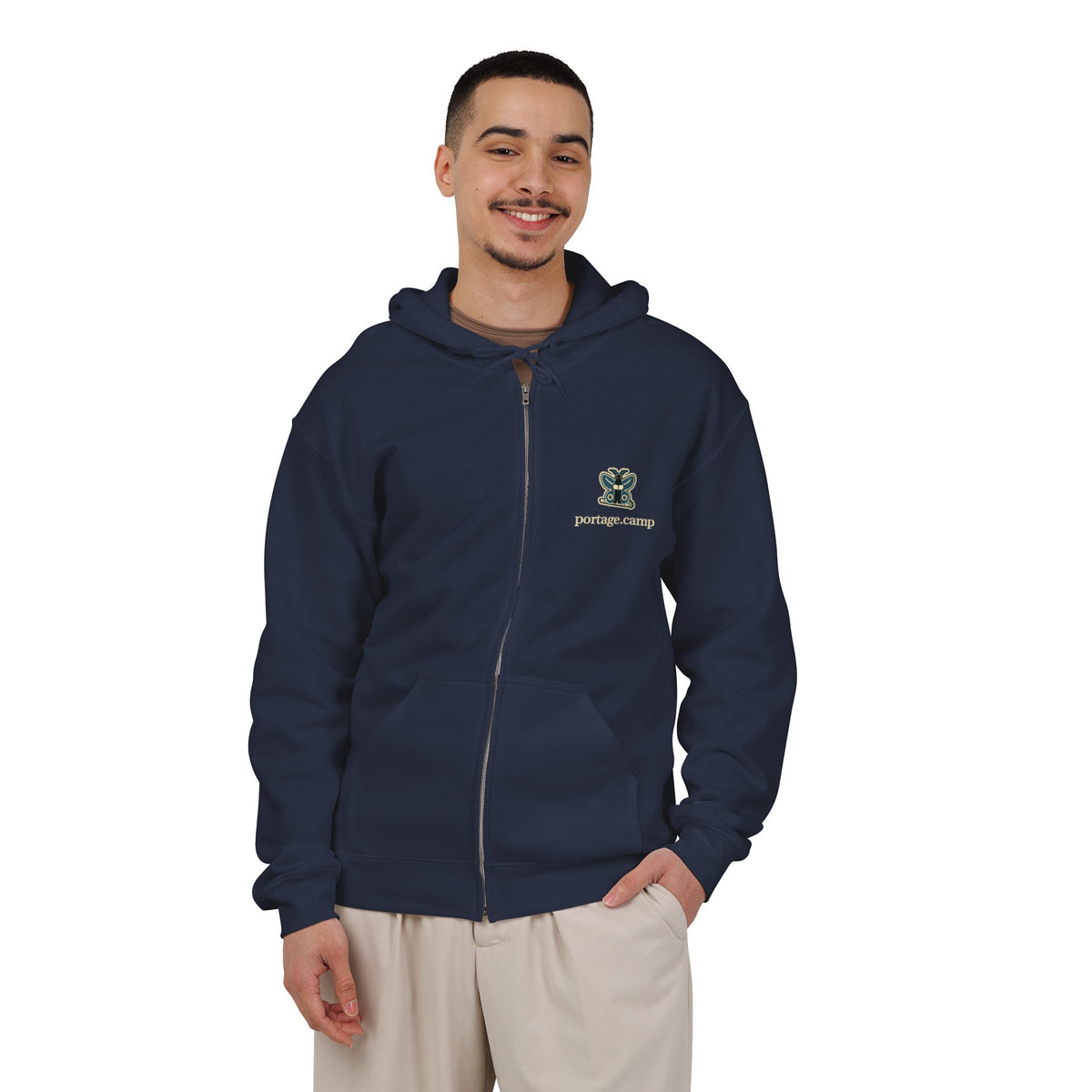 Night Library Zip Hoodie in Navy, worn by a man in a plain white studio, with the Night Library logo and portage.camp on the left chest. Digital product mockup.
