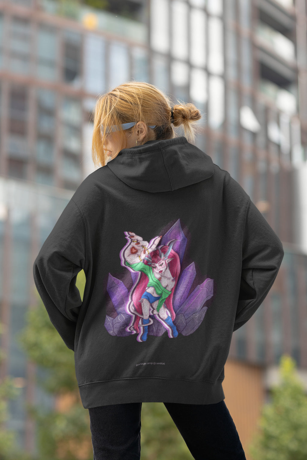 Heart Thief Zip Hoodie in Black, worn by a woman seen from behind by tall city buildings, showing the large print on the back. Digital product mockup.