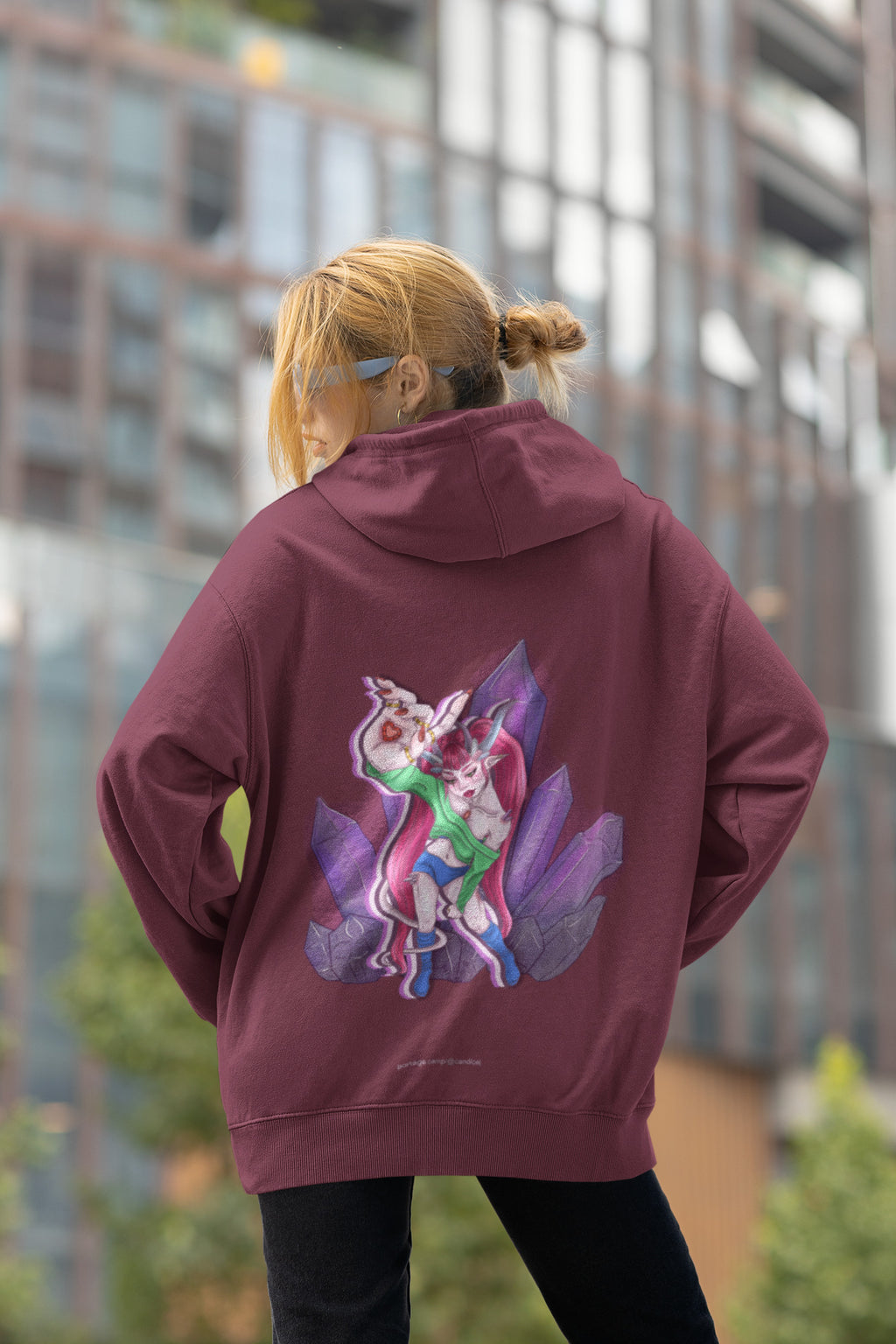 Heart Thief Zip Hoodie in Maroon, worn by a woman seen from behind by tall city buildings, showing the large print on the back. Digital product mockup.