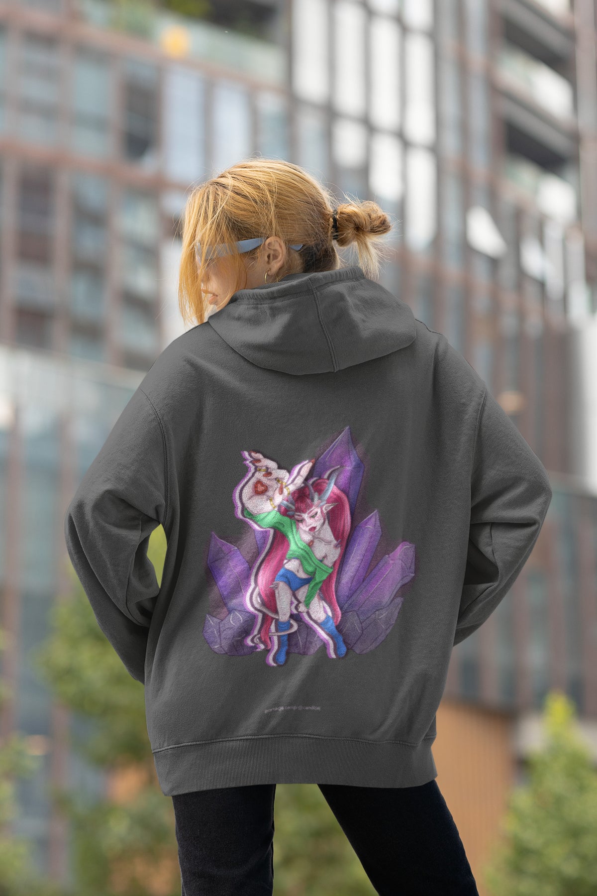 Heart Thief Zip Hoodie in Dark Heather, worn by a woman seen from behind by tall city buildings, showing the large print on the back. Digital product mockup.
