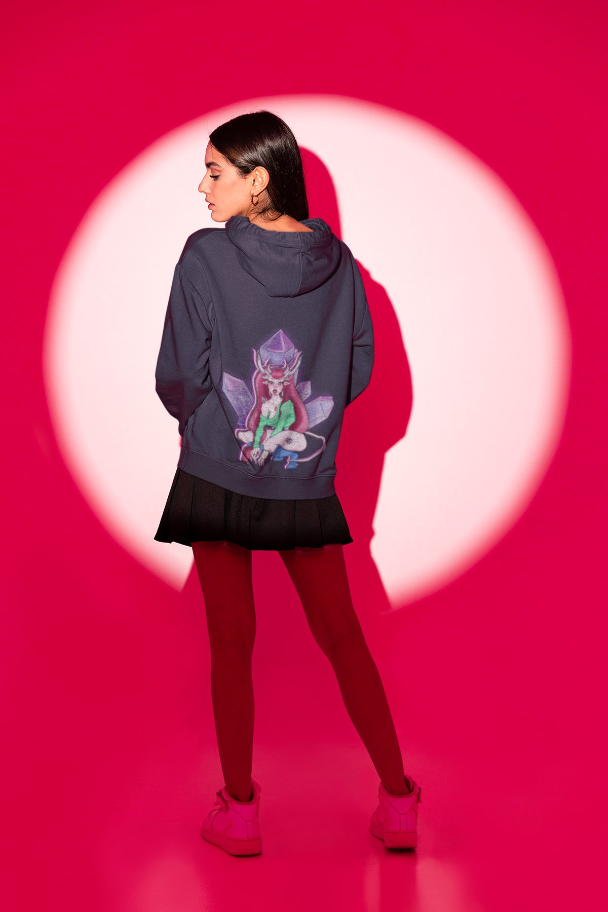 Amethyst After Hours Zip Hoodie in Navy, worn by a woman seen from behind in a studio spotlight, showing the large print on the back. Digital product mockup.