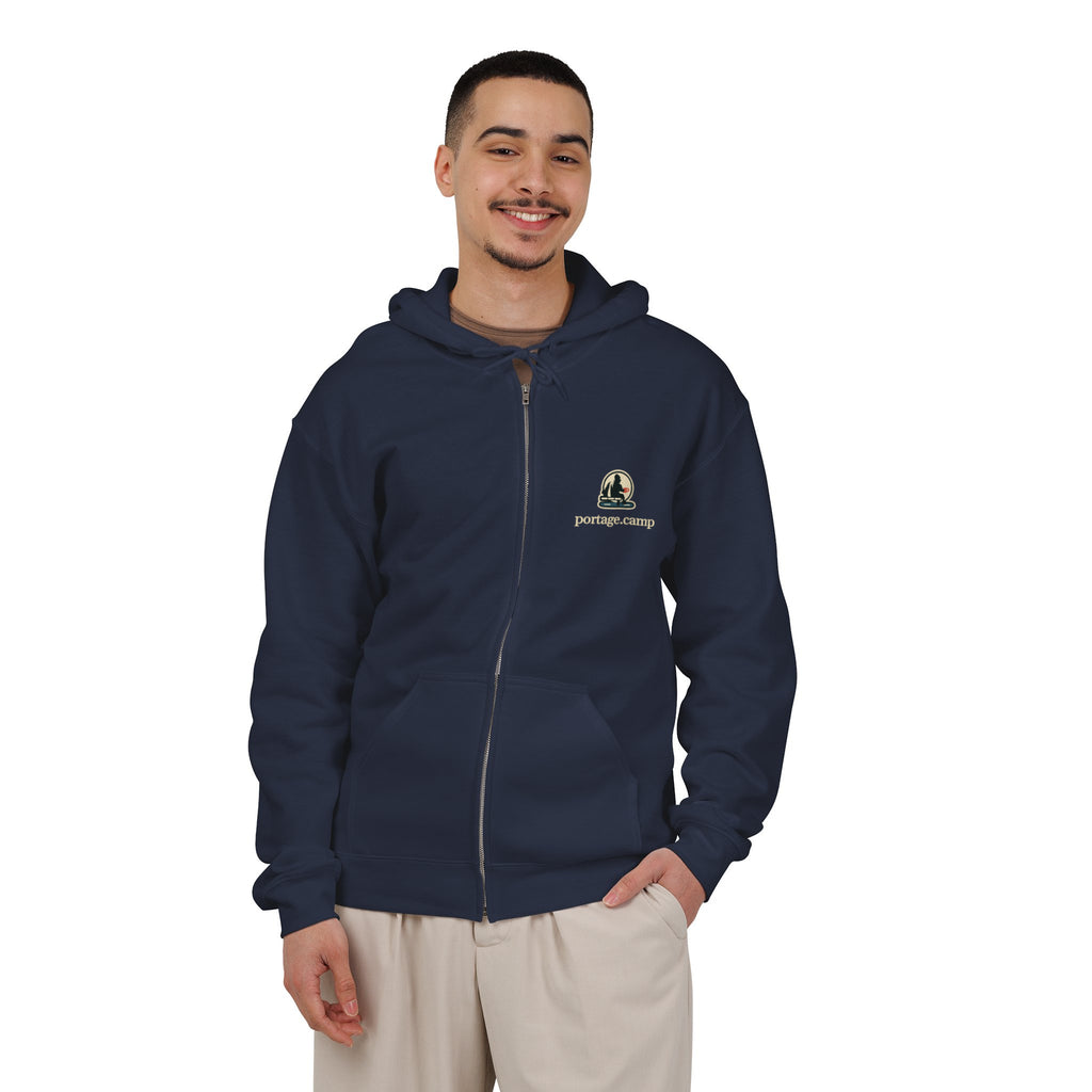 Quiet Hours Zip Hoodie in Navy, worn by a man in a plain white studio, with the Quiet Hours logo and portage.camp on the left chest. Digital product mockup.