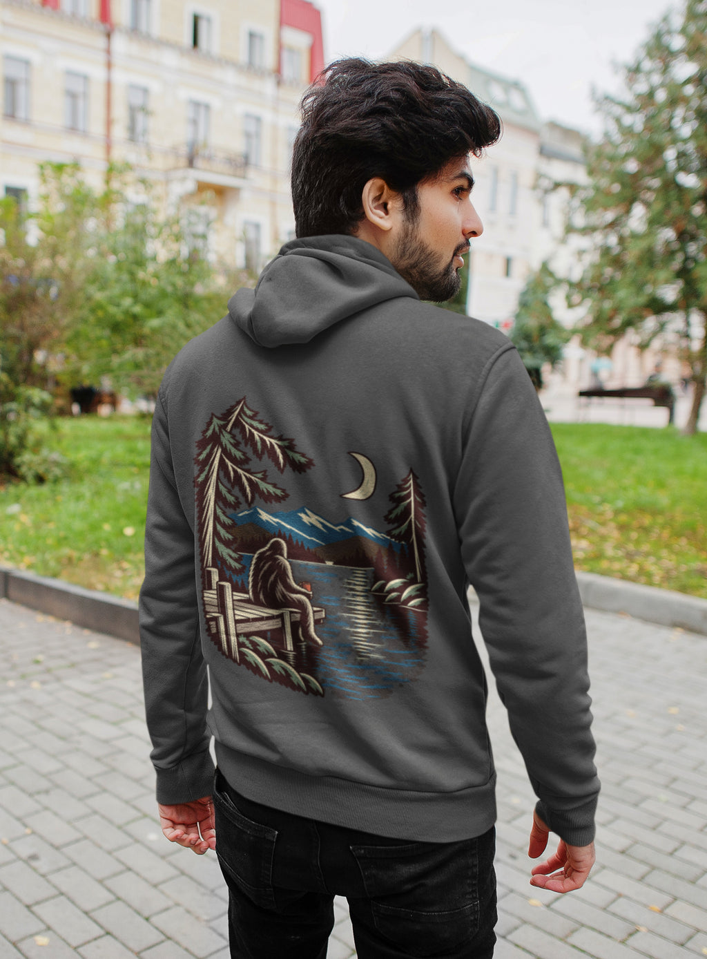 Quiet Hours Zip Hoodie in Dark Heather, worn by a man seen from behind on a quiet city street, showing the large print on the back. Digital product mockup.
