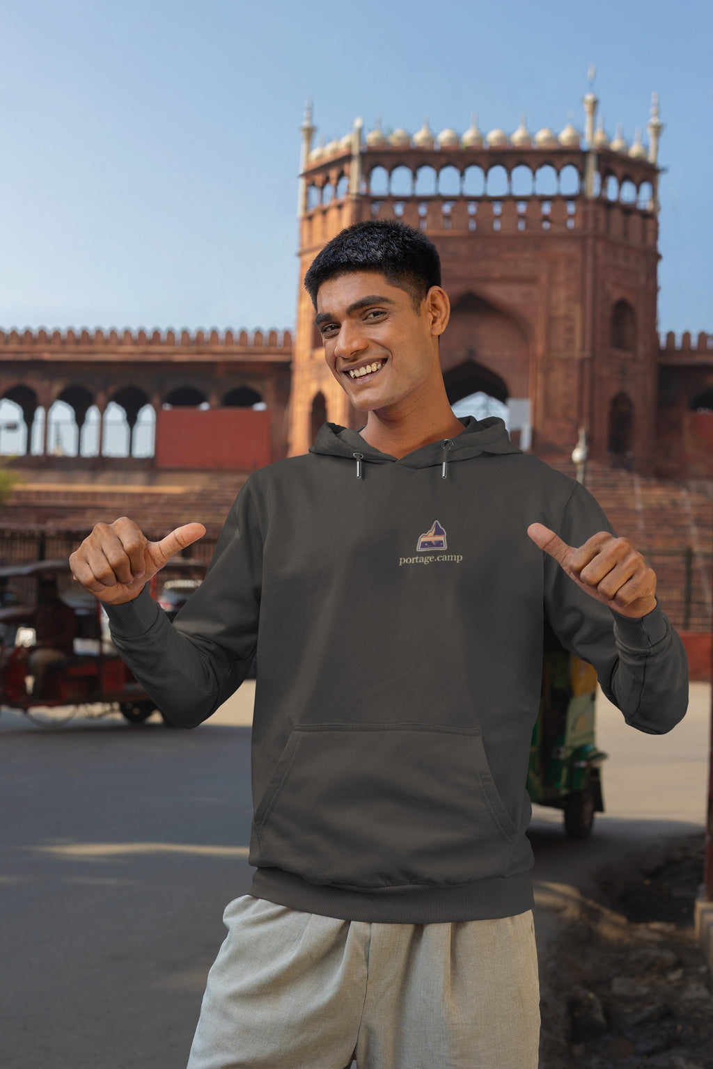 A Different Sky Heavyweight Hoodie in Black, worn by a man on a city street, with the A Different Sky logo and portage.camp on the left chest. Digital product mockup.