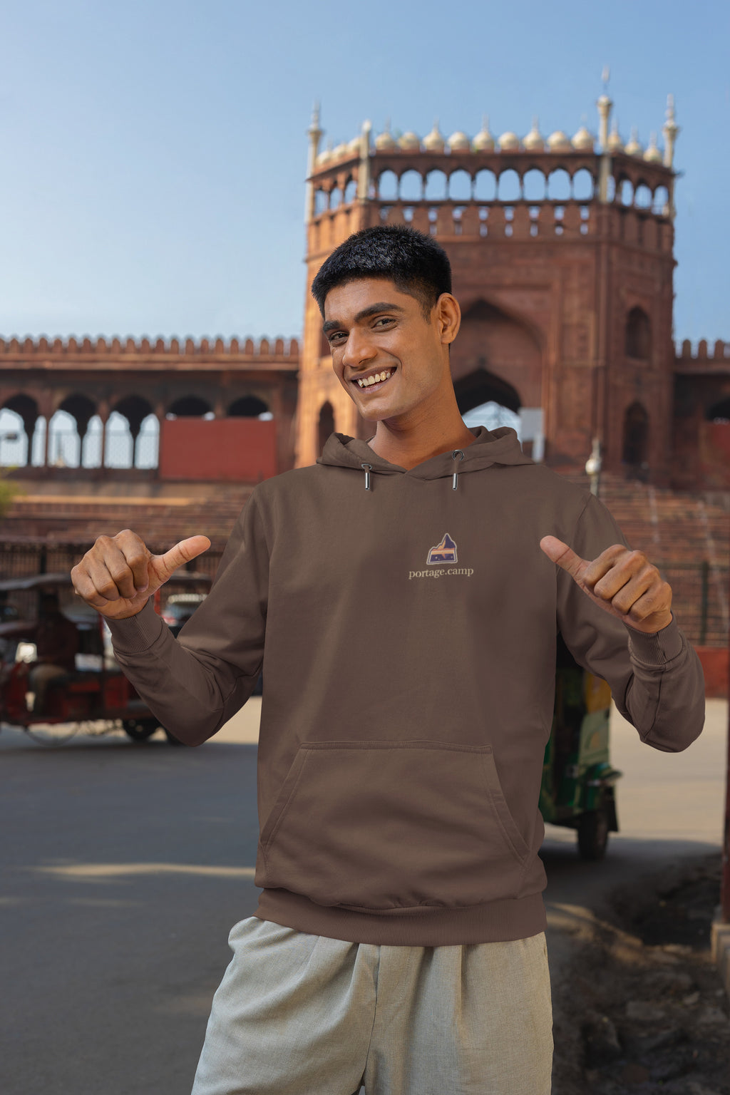 A Different Sky Heavyweight Hoodie in Brown, worn by a man on a city street, with the A Different Sky logo and portage.camp on the left chest. Digital product mockup.