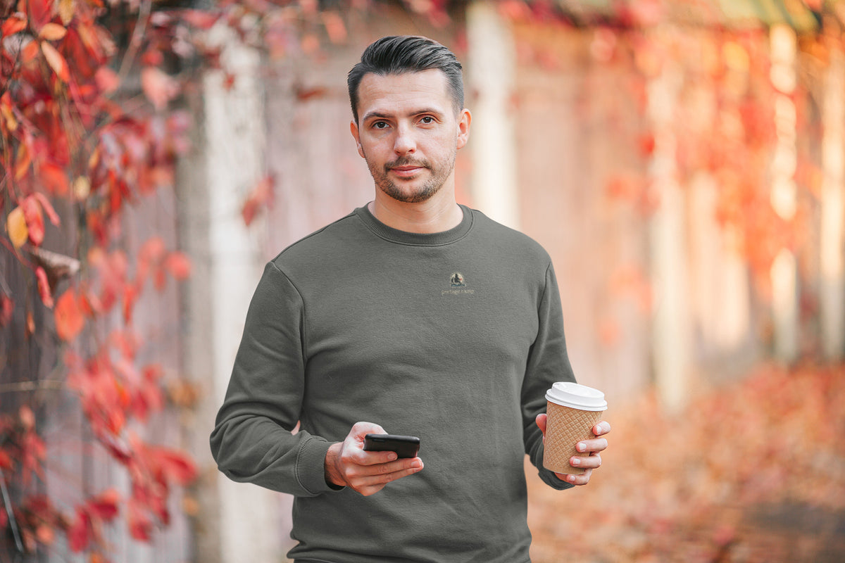 Quiet Hours Garment-Dyed Crewneck in Pepper, worn by a man among autumn leaves, with the Quiet Hours logo and portage.camp on the chest. Digital product mockup.