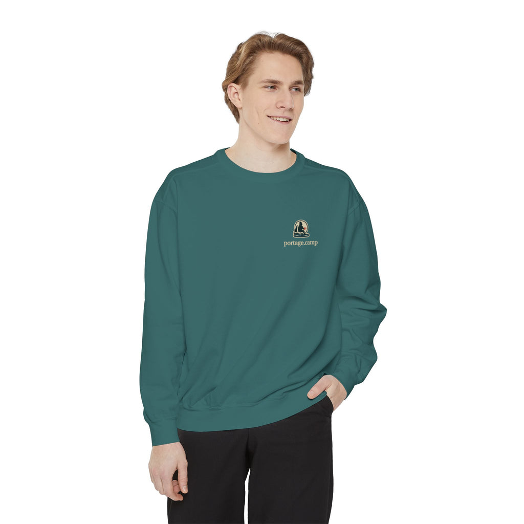 Quiet Hours Garment-Dyed Crewneck in Blue Spruce, worn by a man in a plain white studio, with the Quiet Hours logo and portage.camp on the chest. Digital product mockup.