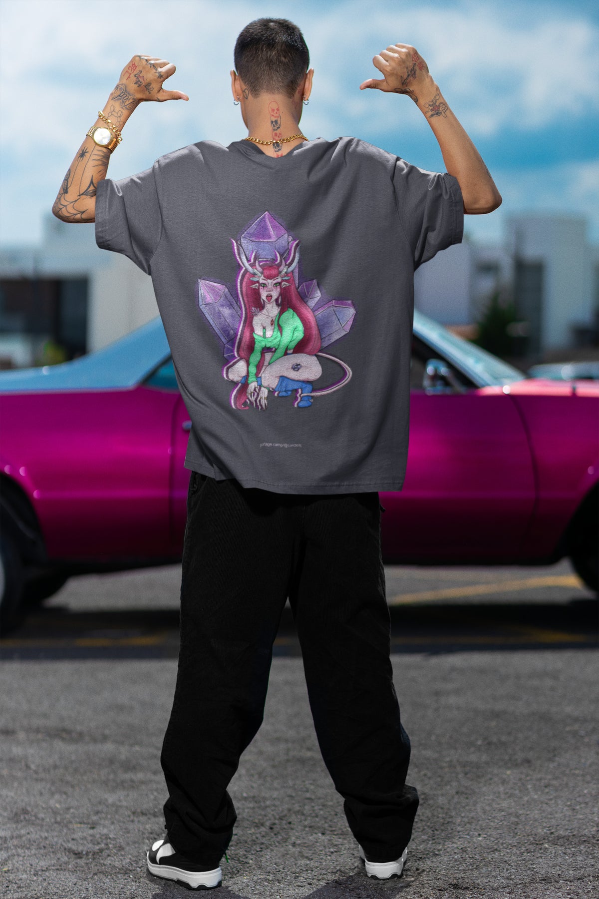 Amethyst After Hours Garment-Dyed Tee in Navy, worn by a man seen from behind by a pink car, showing the large print on the back. Digital product mockup.